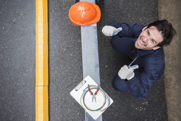 high-angle-view-happy-male-electrician-showing-thumb-up-workplace